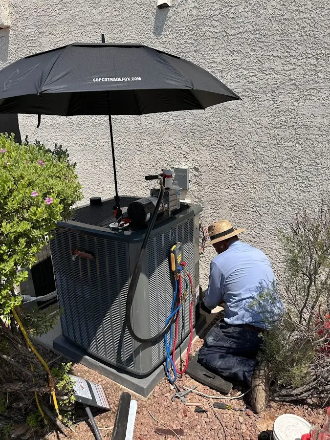 HVAC technician performing outdoor AC maintenance in Rendon