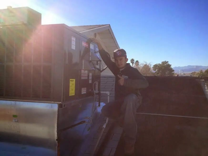 HVAC technician performing HVAC Inspection on a rooftop unit in Rendon